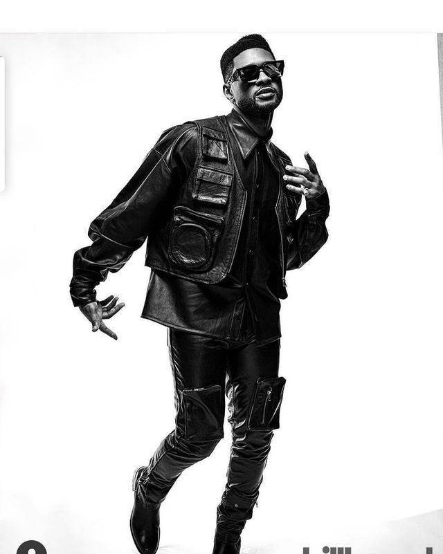 Usher Raymond IV posing in a black jacket, pants and goggles.